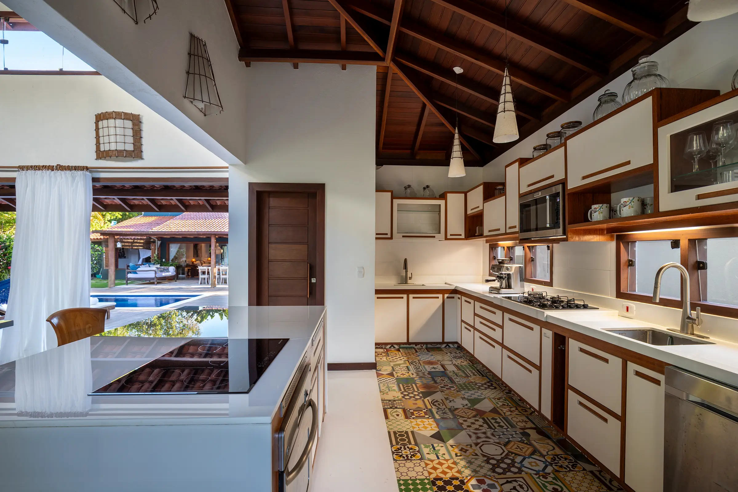 Cozinha com armários brancos e ladrilhos hidráulicos coloridos no piso