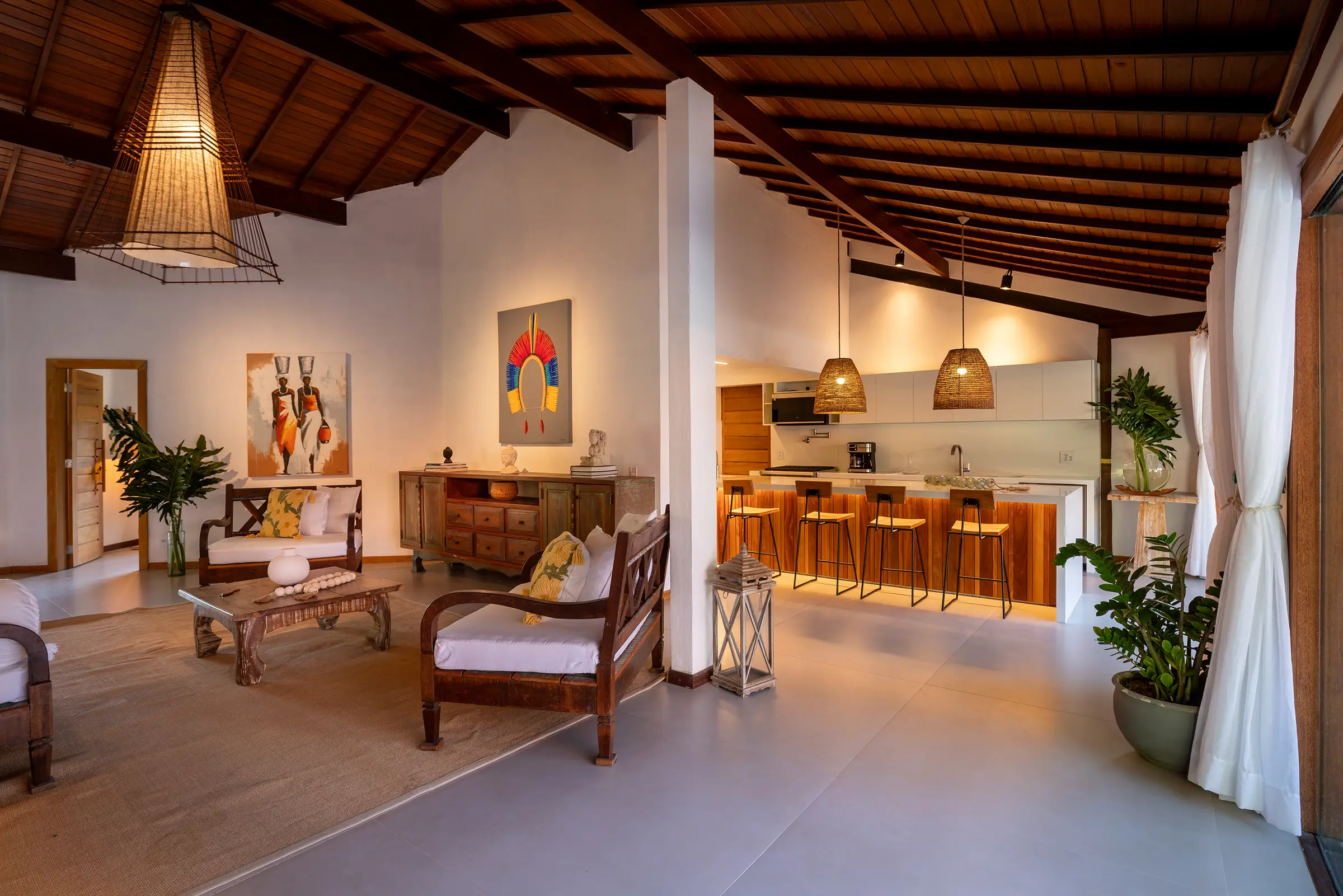 Sala com arte na parede e a cozinha ao fundo